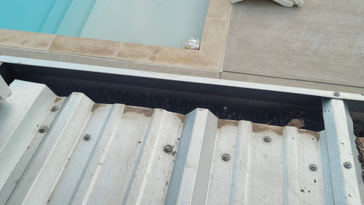 metal building gutter with GutterBrush clog protection and gutter cleaning decreaser installed