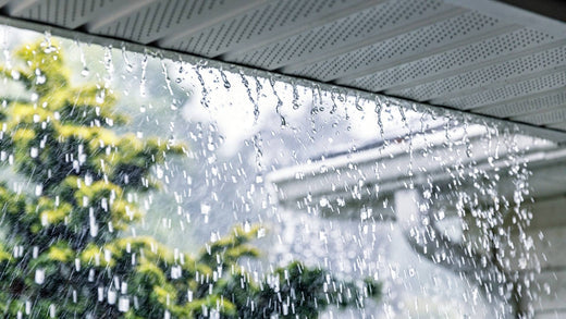 rain gutter with gutter guard foam clogged and pouring over